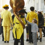 A child asks to touch the tassel of a Tuba player