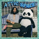This is a photo of musician Abraham Khan sitting on a bench next to an enormous stuffed panda, with the name of his band, Attic Space, above them.