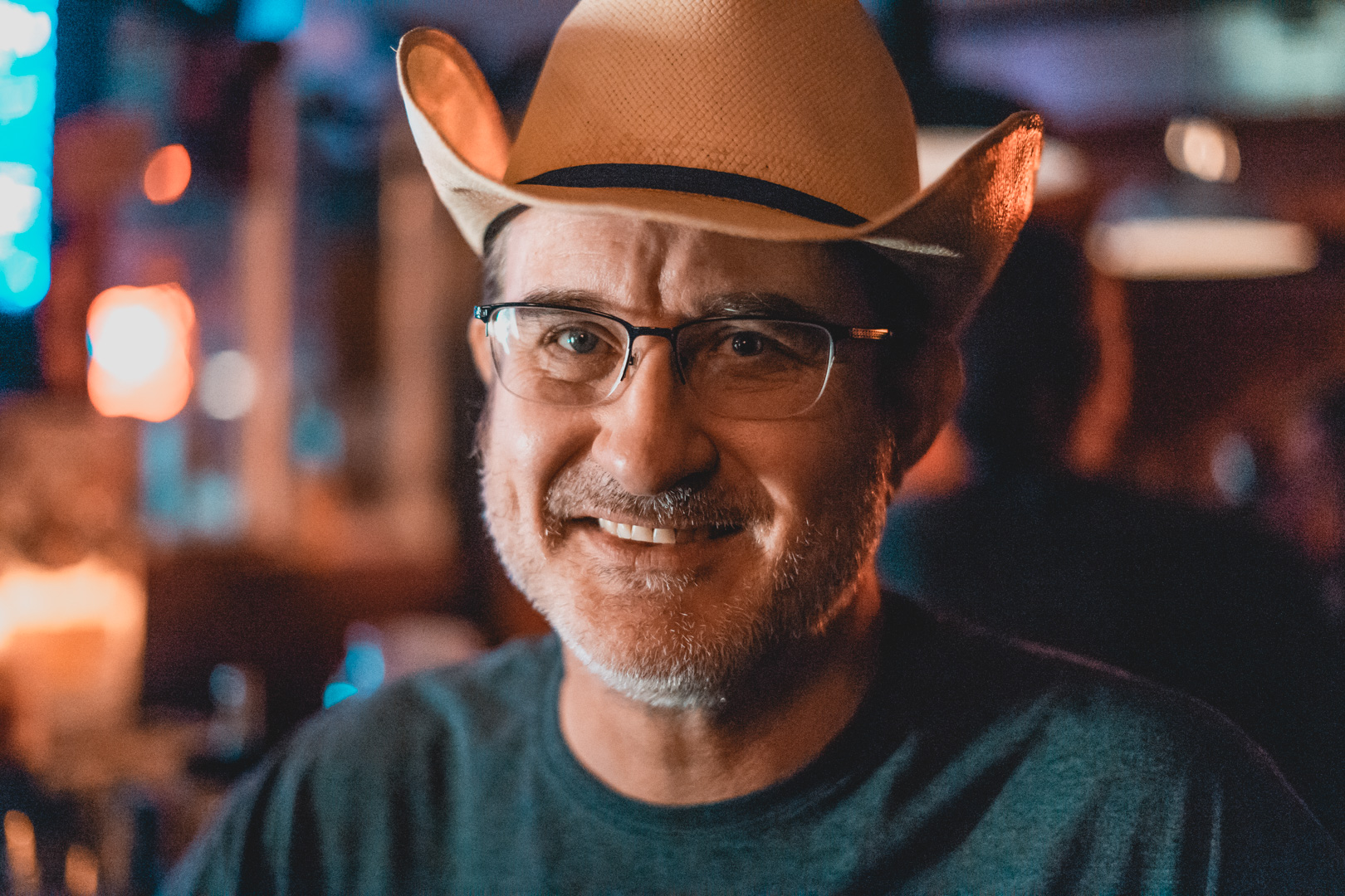 A portrait of a man in a cowboy hat smiling.