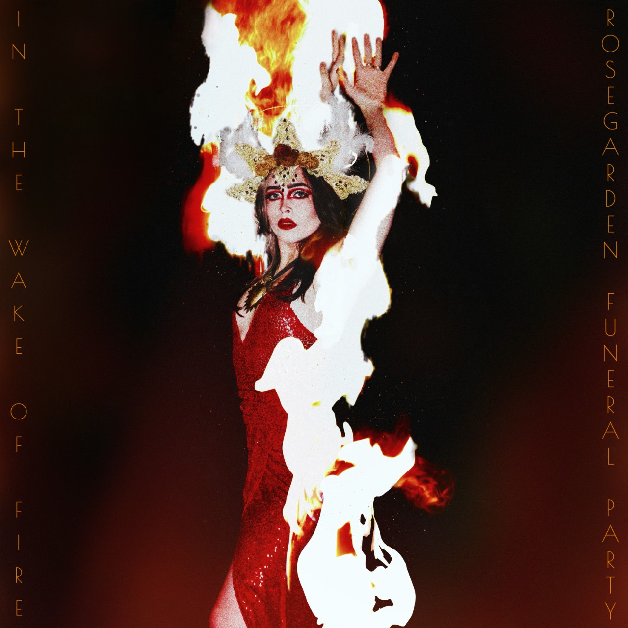 A woman wearing a red dress, is seen on fire, raising her arms to the sky