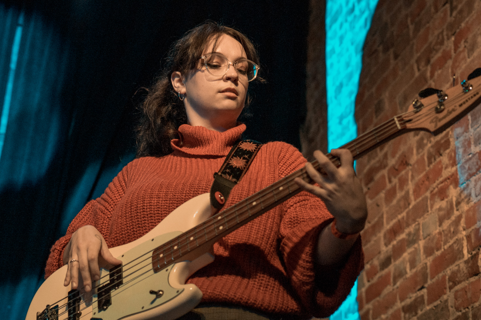 A young woman plays bass