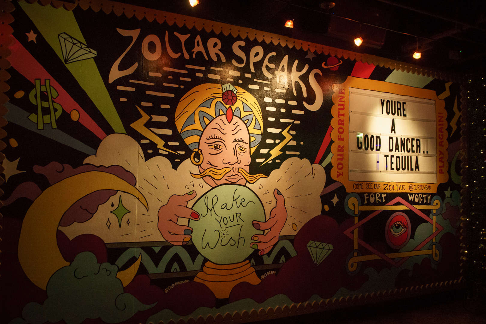 A wall mural of a fortune teller and a marquee 
