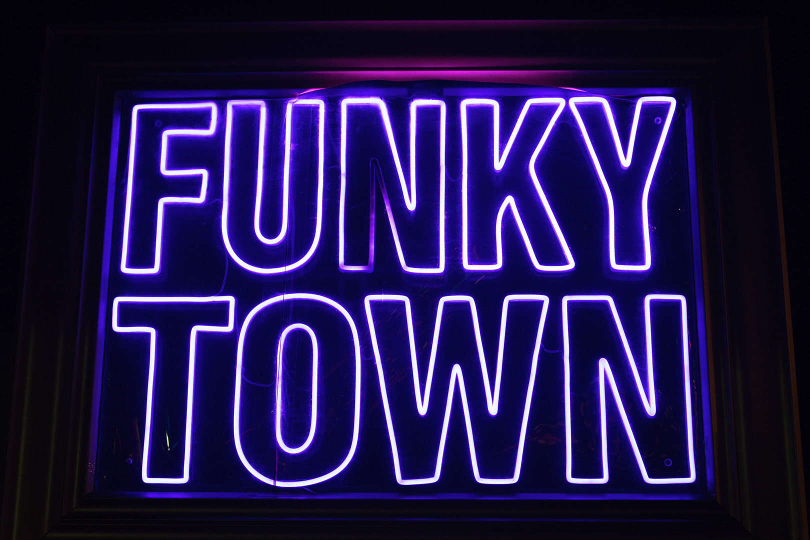 A neon sign says "FUNKY TOWN"