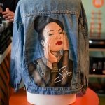 A denim jacket with a painted portrait of Selena