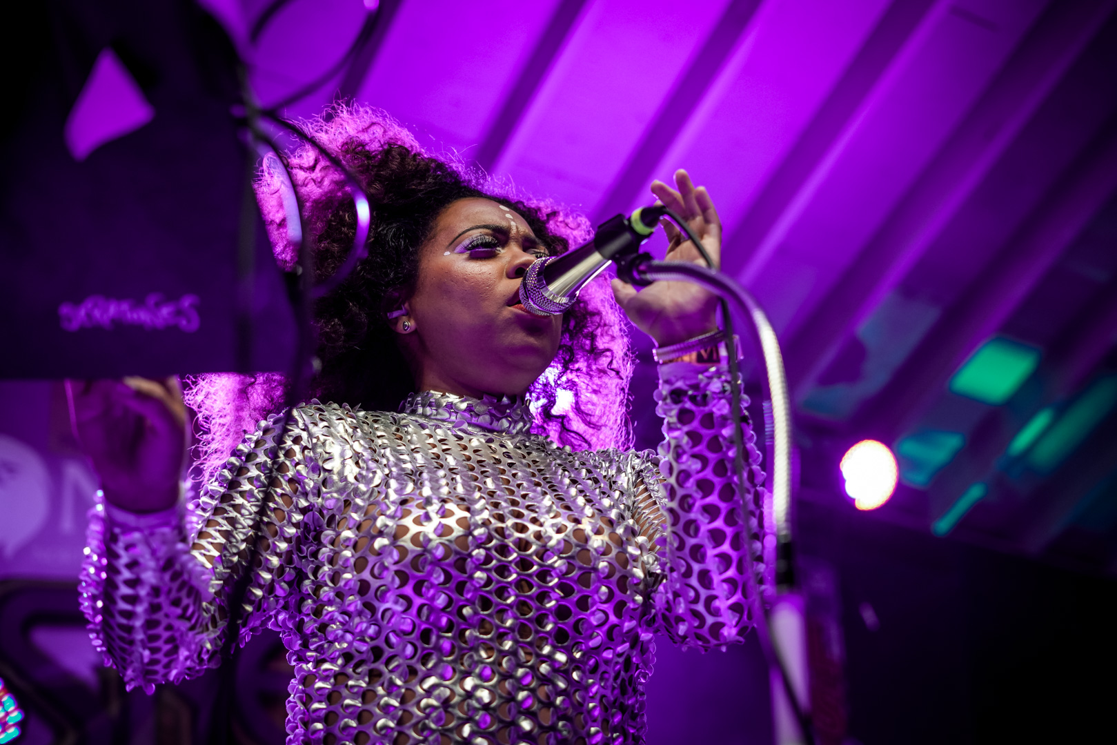 A young woman in sequin jumpsuit sings