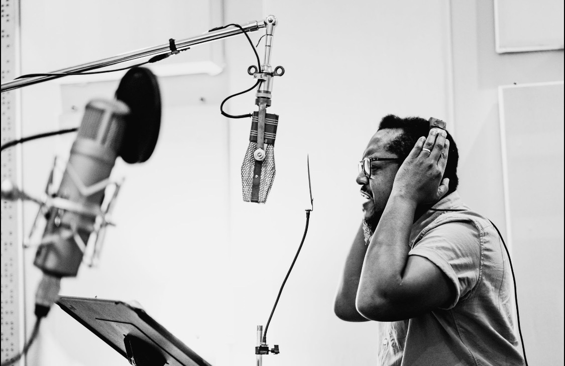 Chadwick Murray, wearing headphones, performs in a recording studio