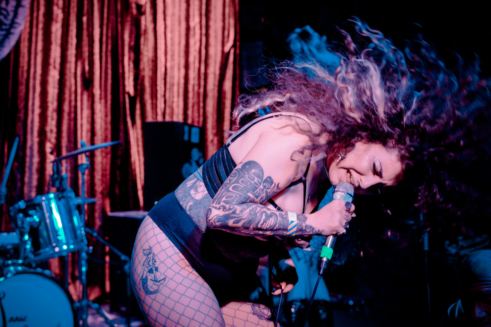 A woman headbangs with big hair on stage