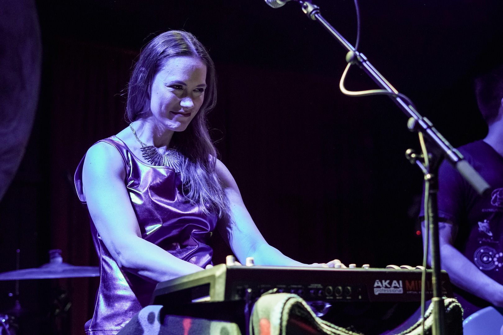 A woman smiles and plays keys