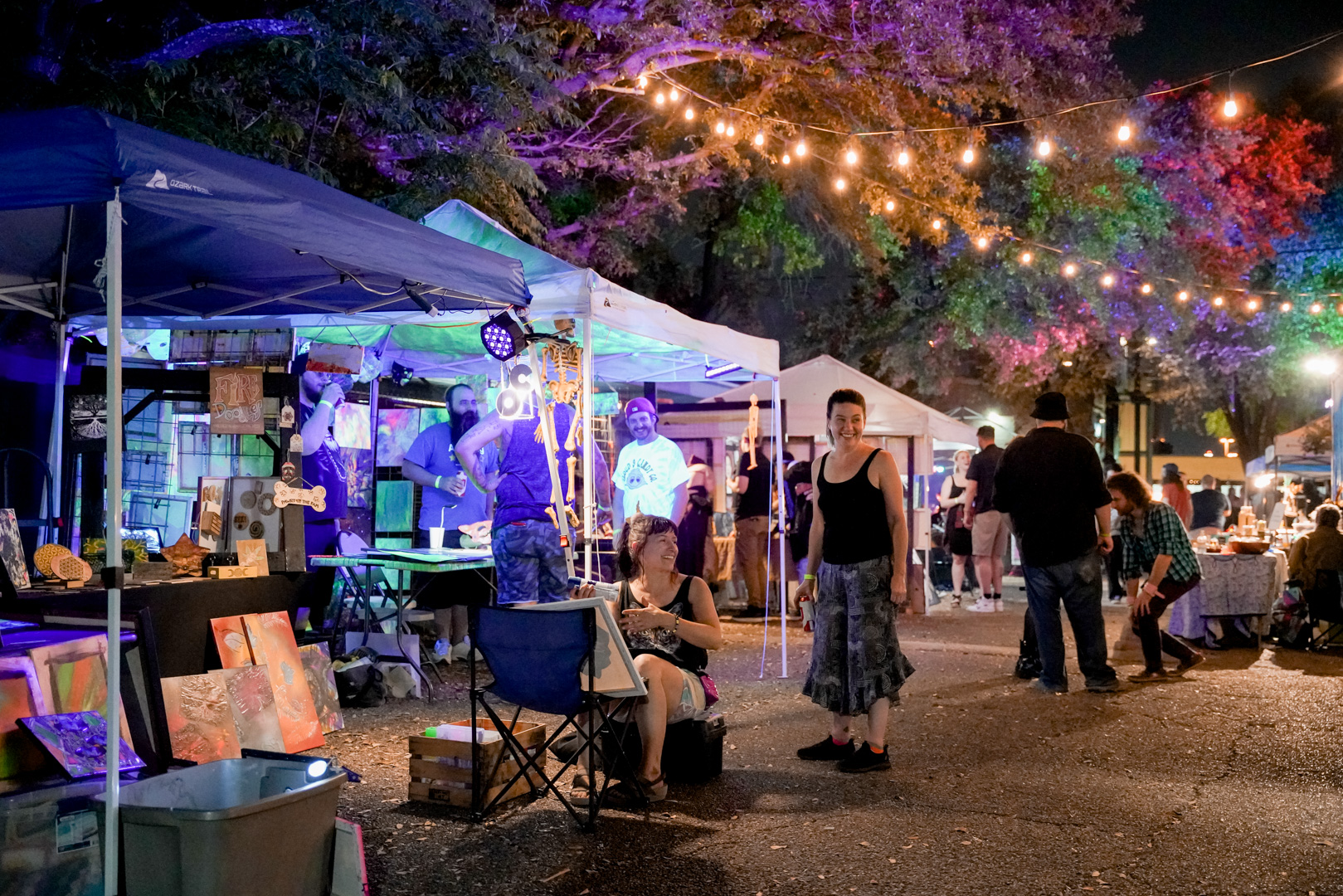 Vendor booths set up outside in colorful night scene