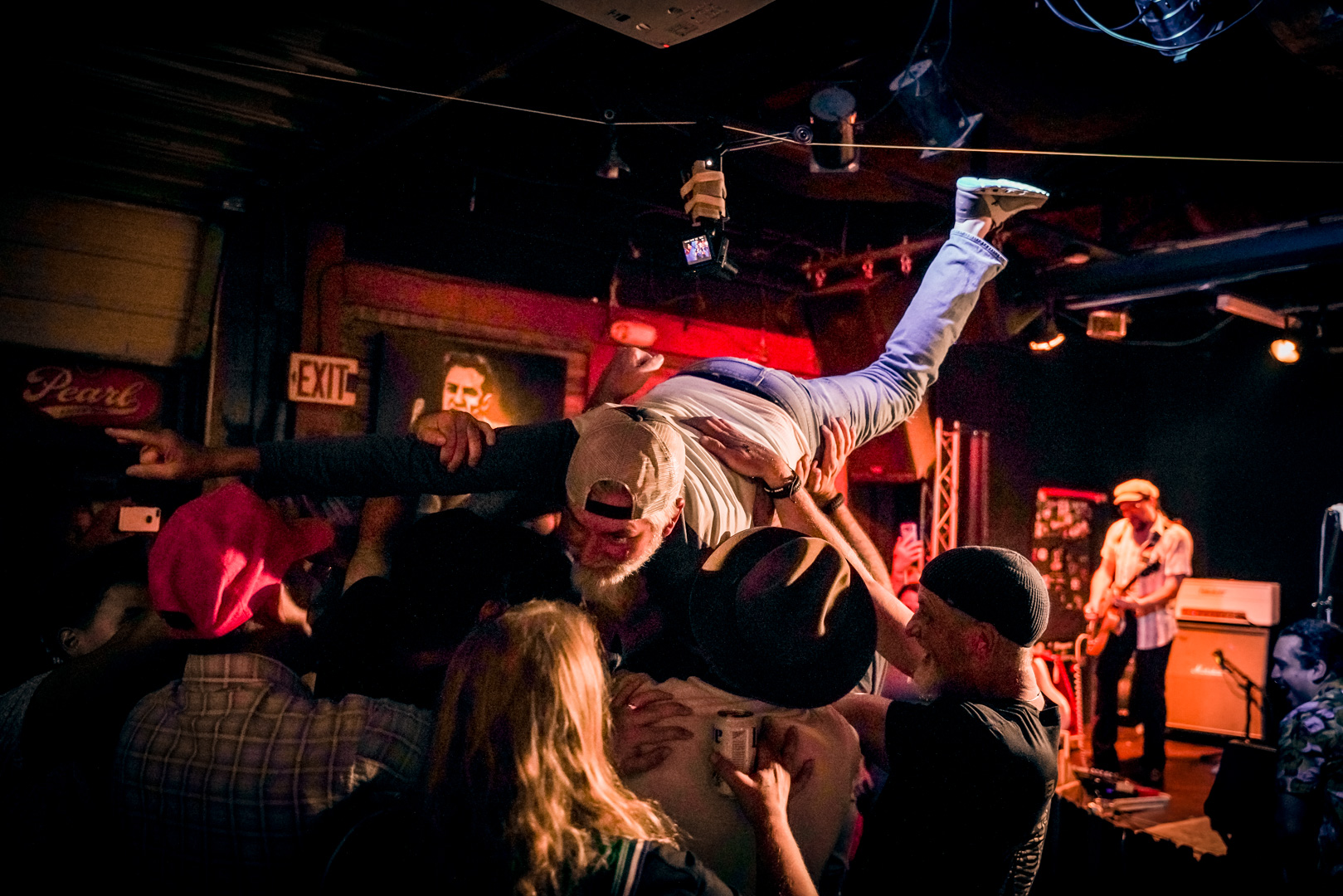 A man crowd surfing in a small crowd