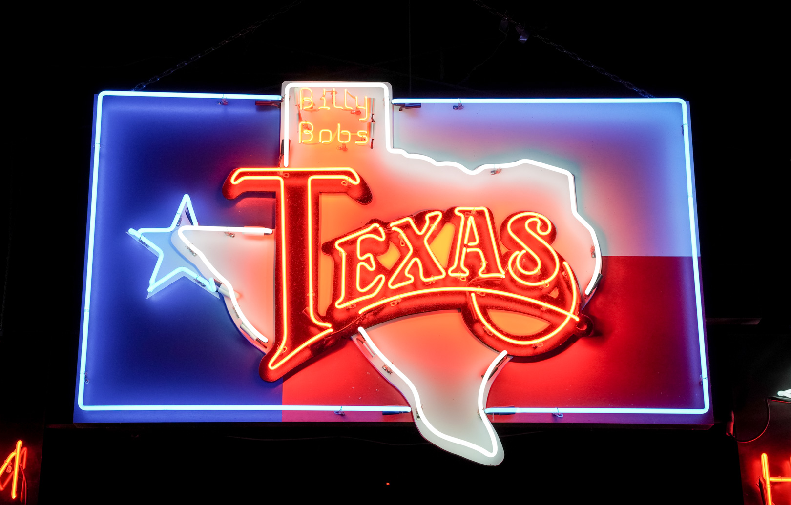A neon sign with Texas state flag