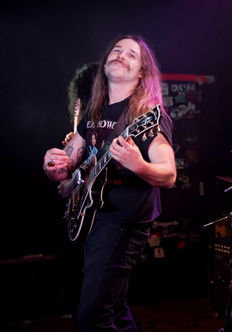 A guitarist grinning on stage