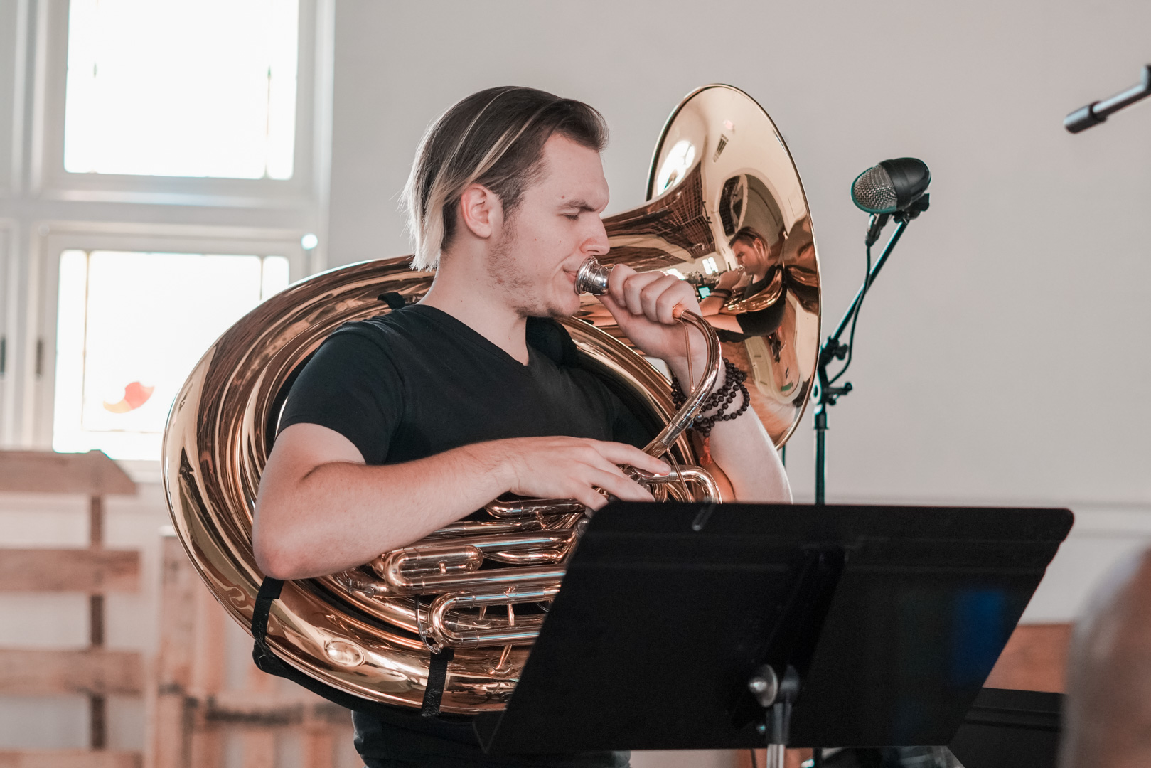 A young man plays helicon horn instrument