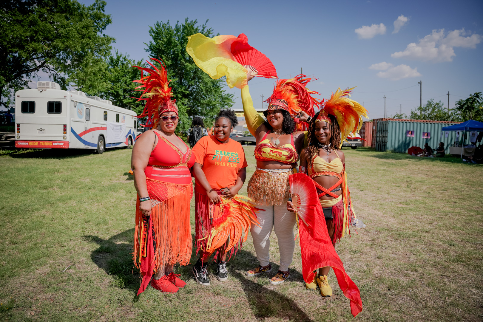 Four women in red, orange and yellow dance outfits