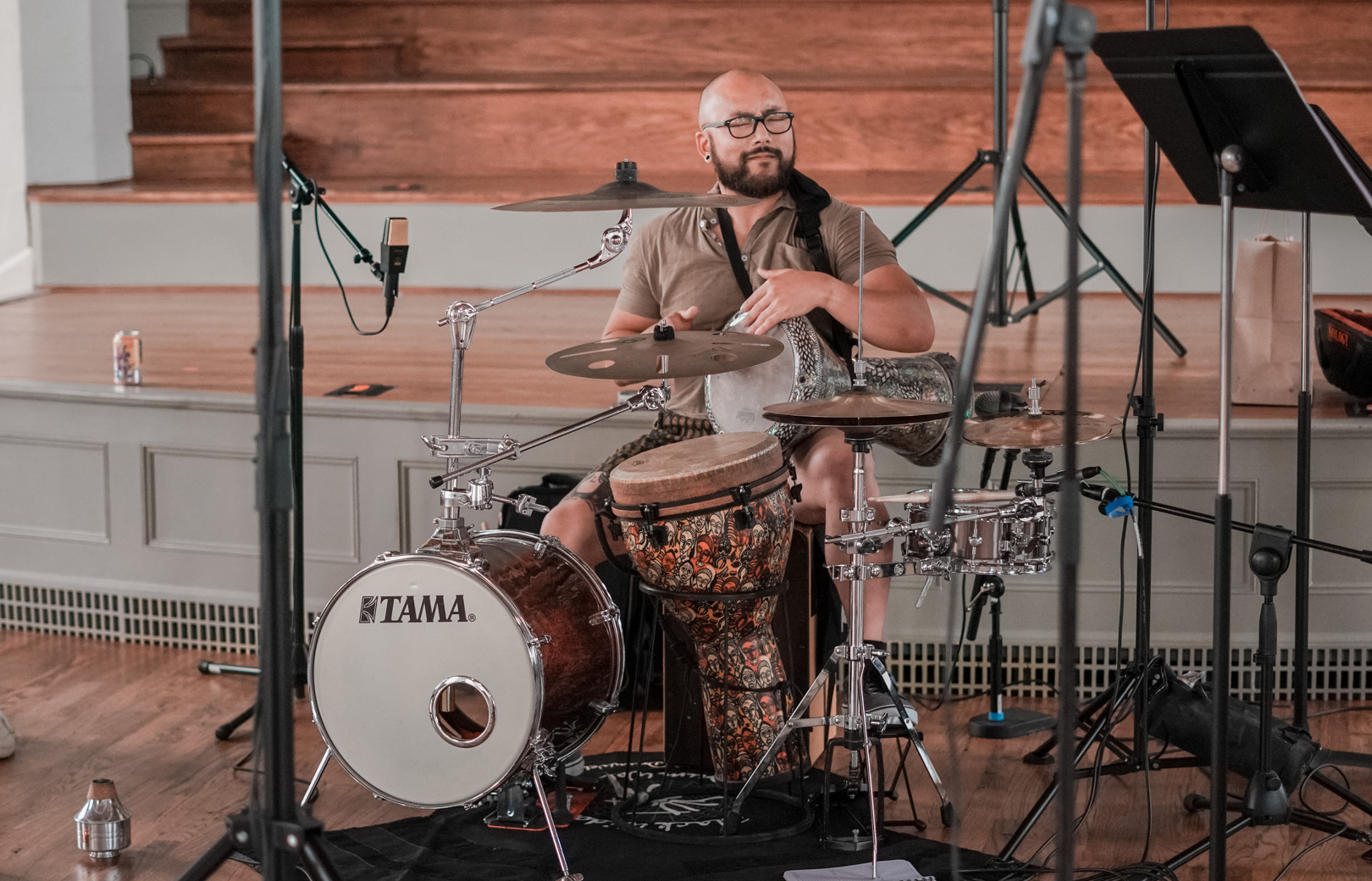 A young man plays drums and percussion