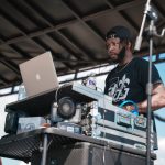 A young man djs on stage