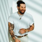 Wearing all white, Koe Wetzel smiles at the camera