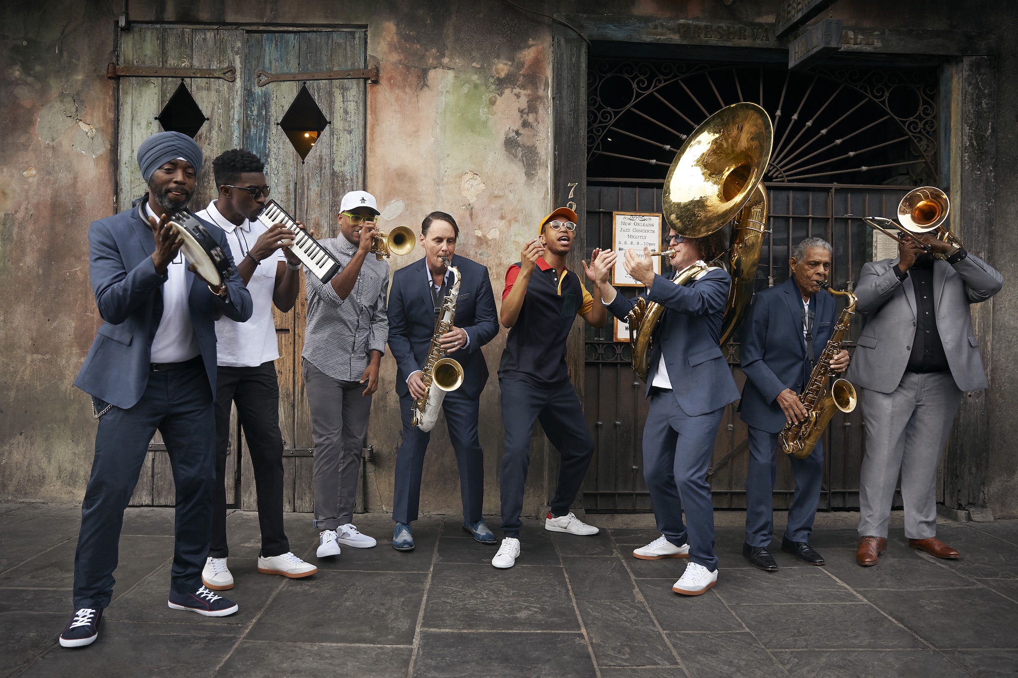 The Preservation Hall Jazz Band stands in front of the New Orleans venue, holding its instruments