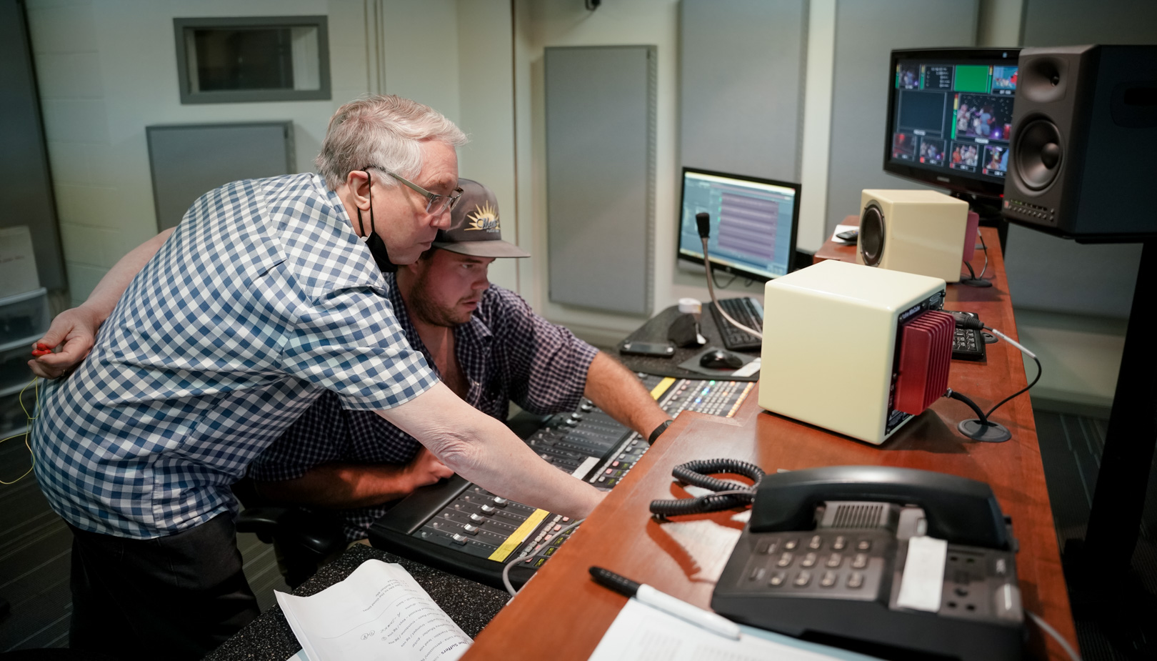 Two people at an audio board