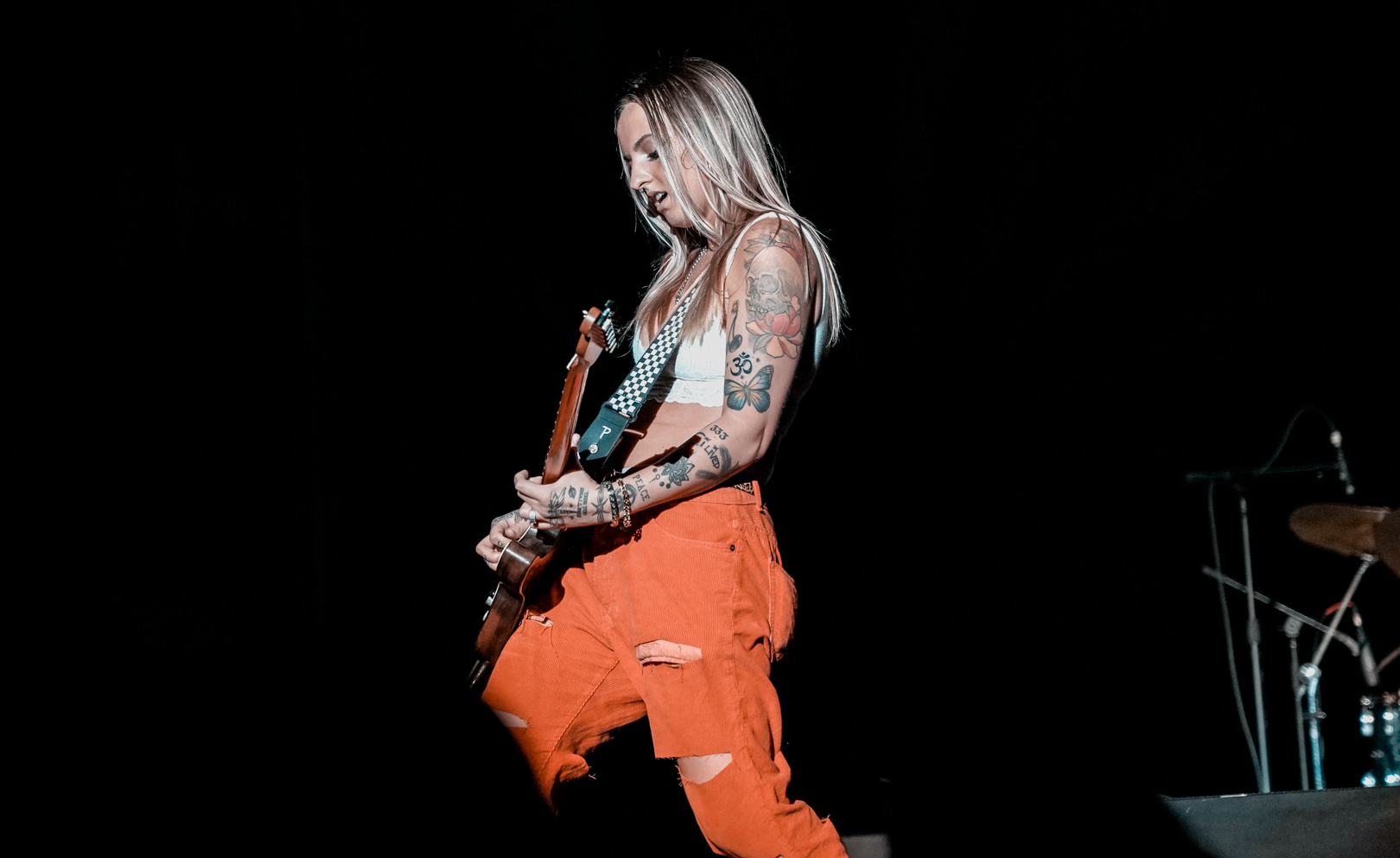 A woman plays guitar on stage