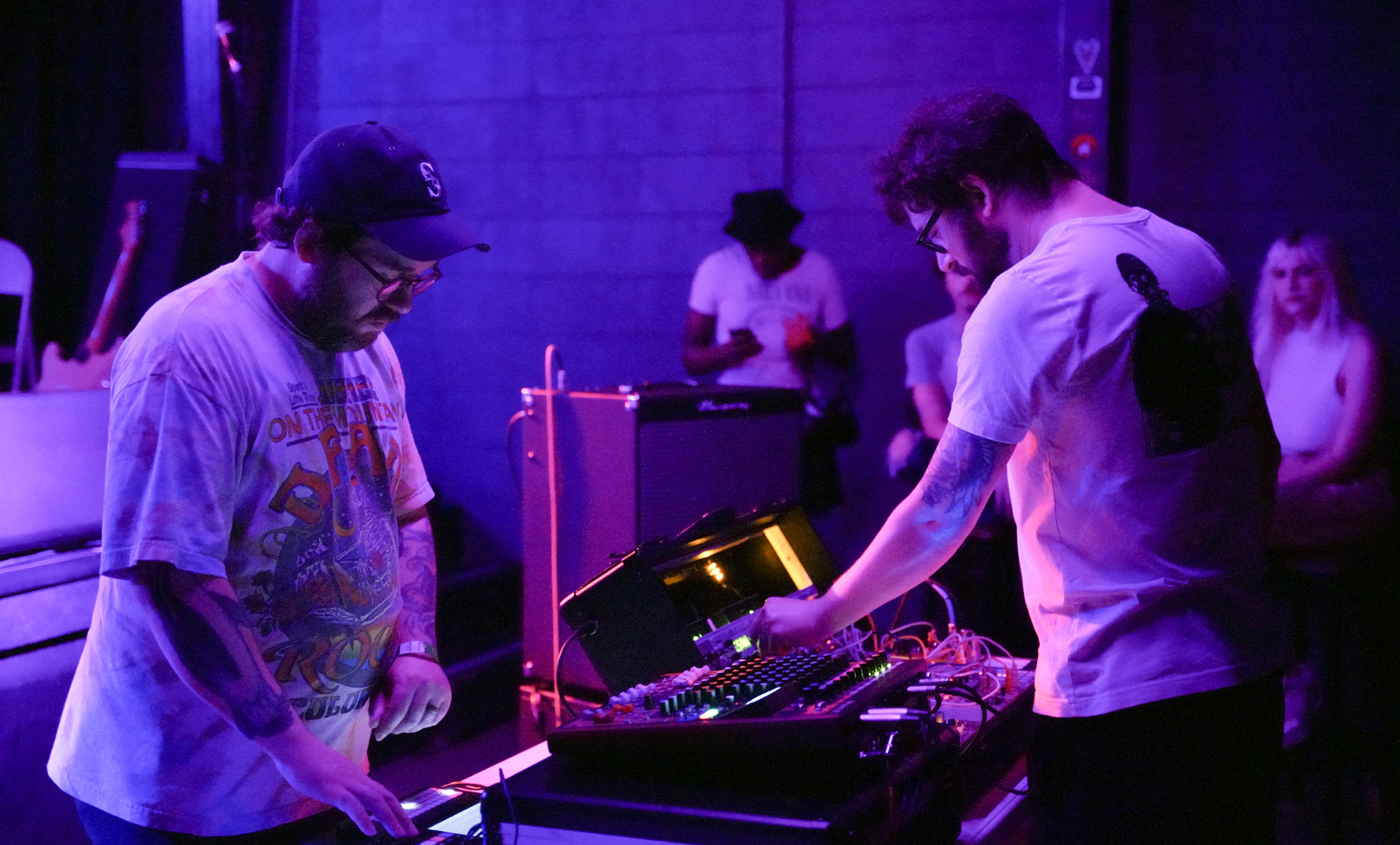 Two people playing with synth machines