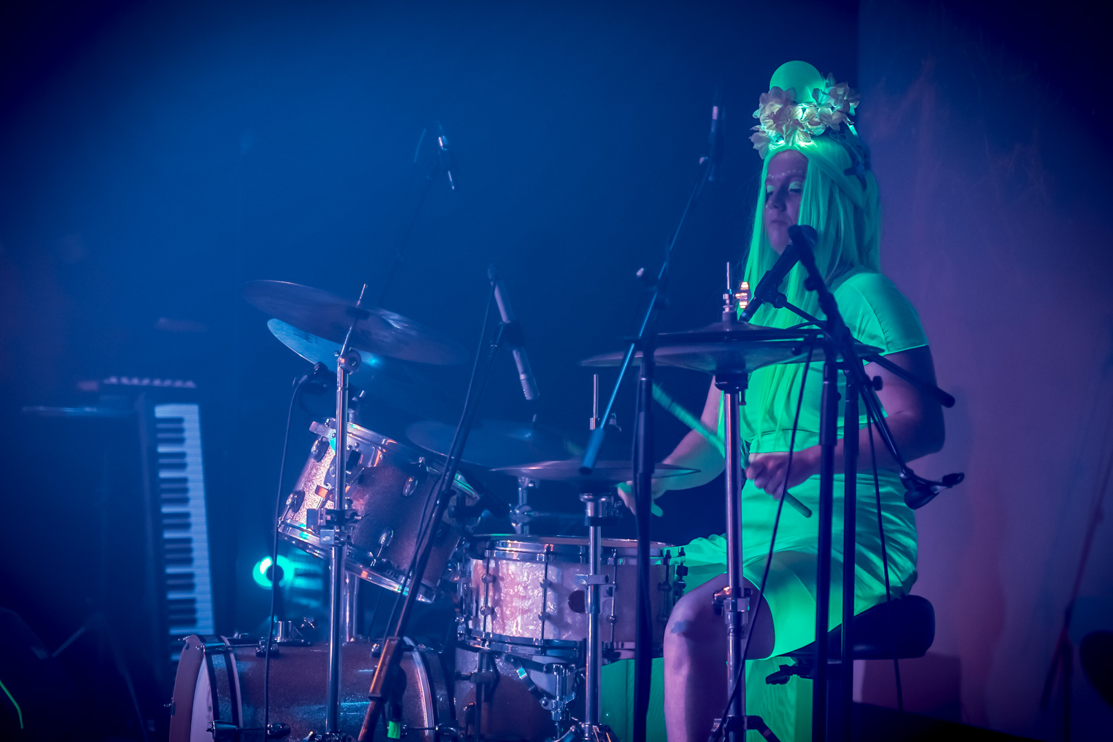A drummer in neon green outfit on stage