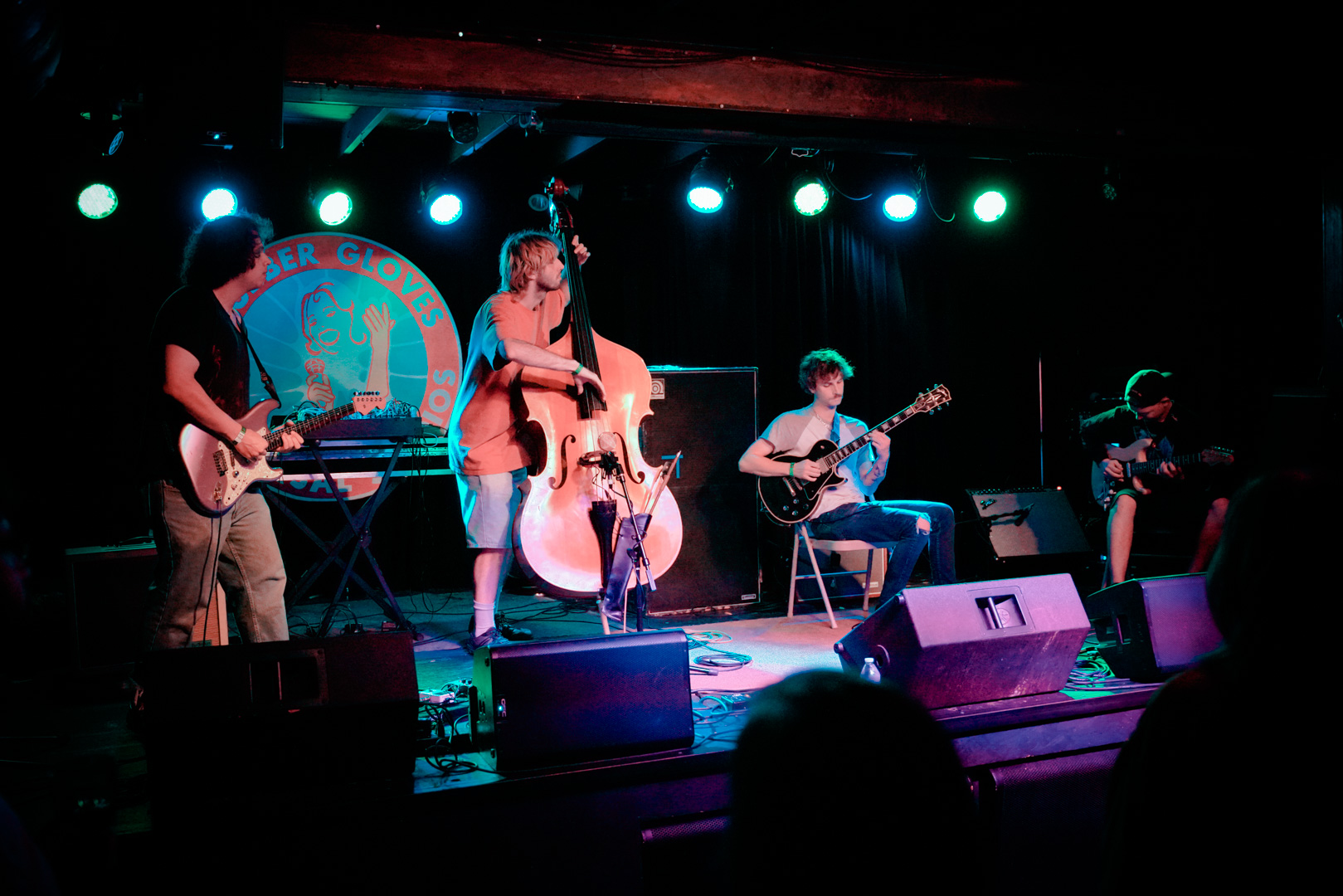 Three guitarists and an upright bass player on stage