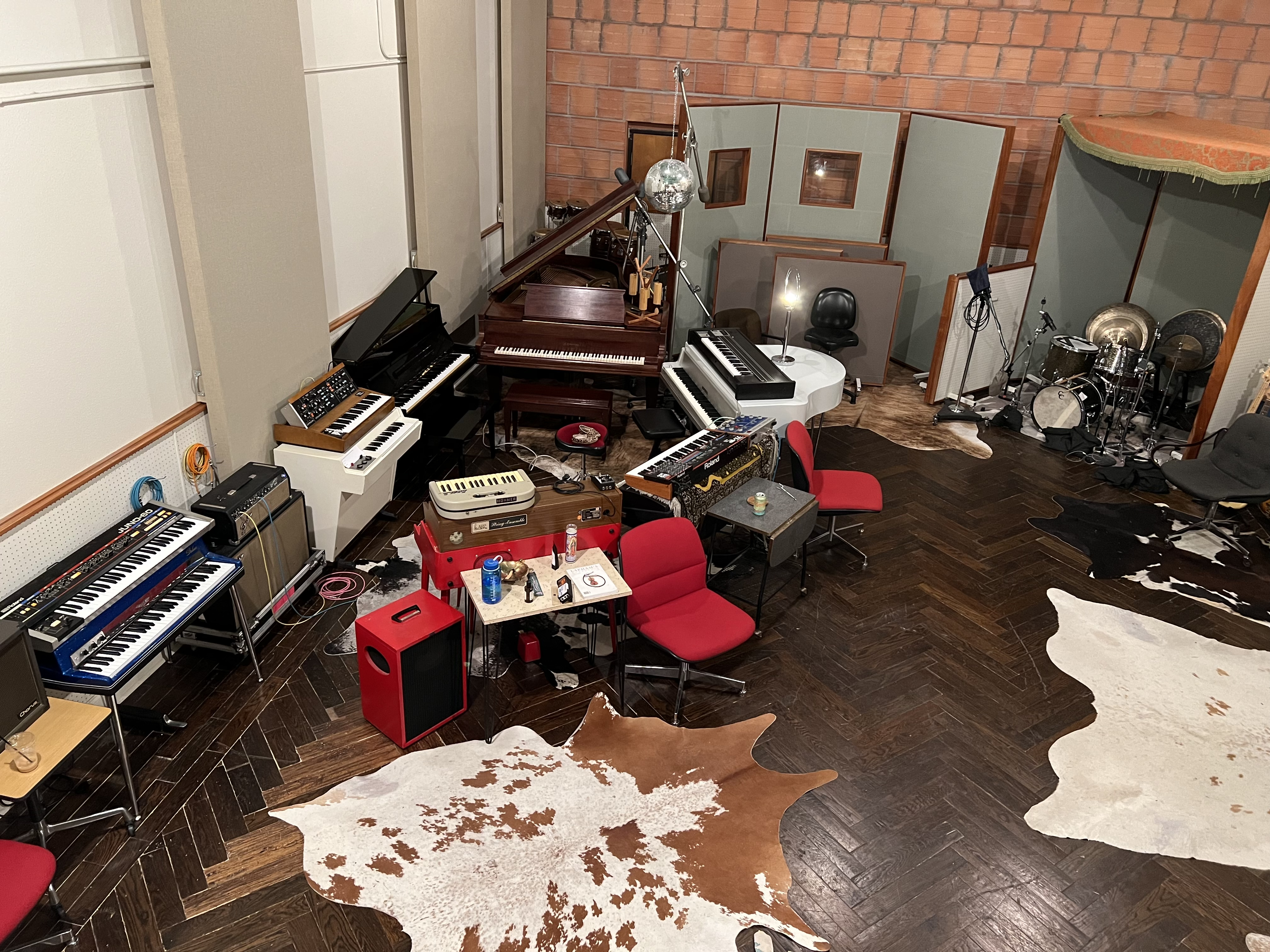 The inside of Niles City Sound shows an array of pianos, along with a cowskin rug and a disco ball hung above the instruments.