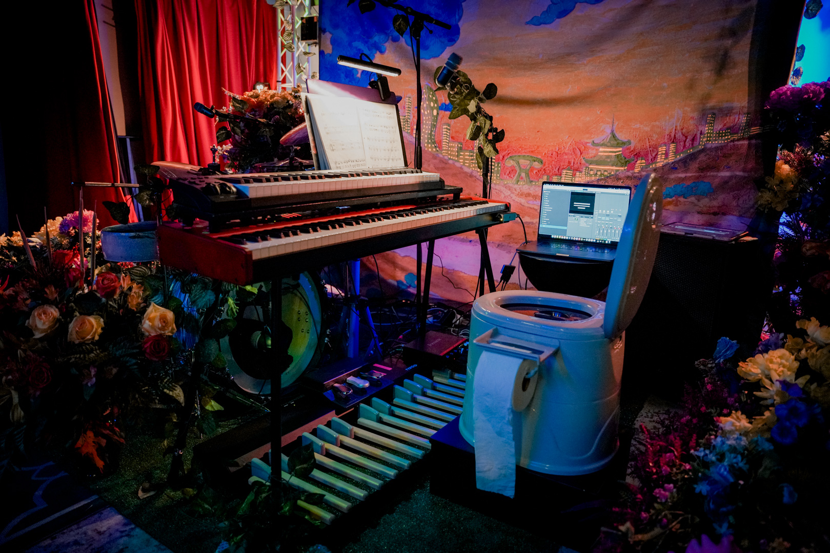 A toilet on stage with keyboards