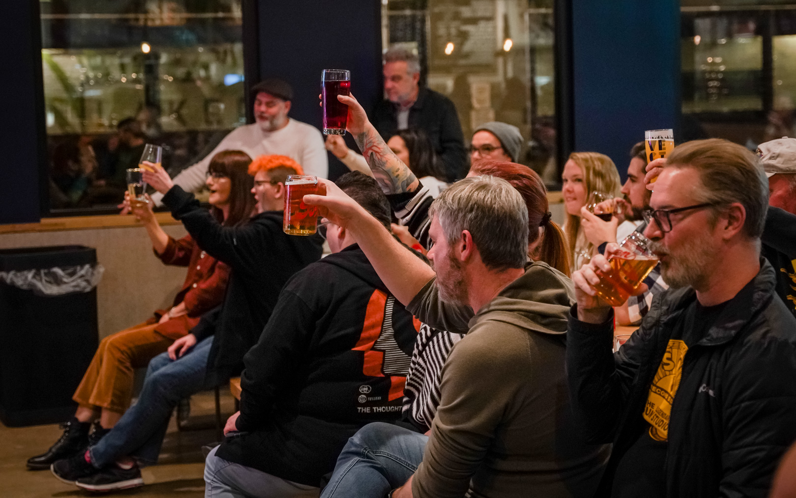 A crowd sitting raising glasses of beer
