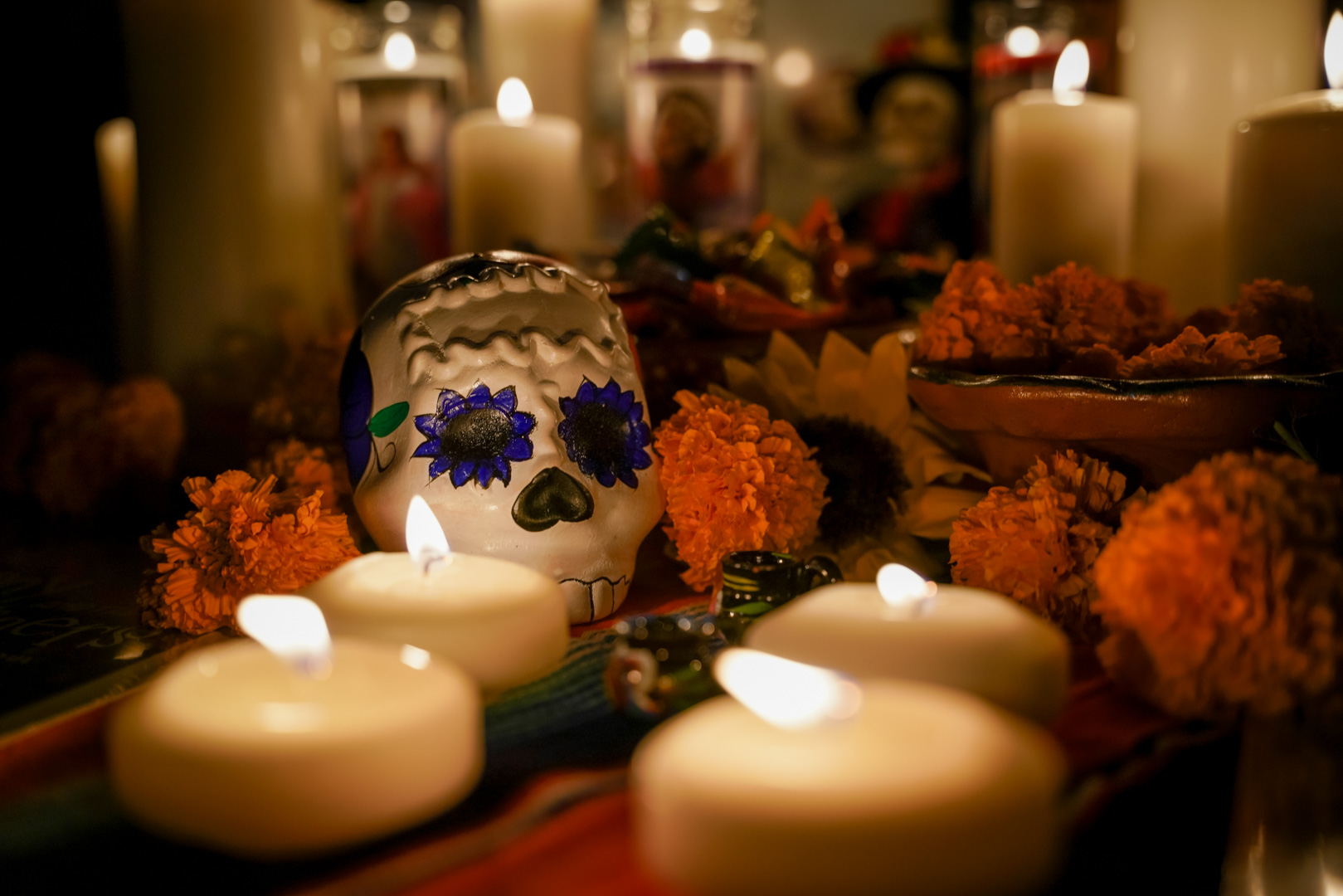 A sugar skull surrounded by candles
