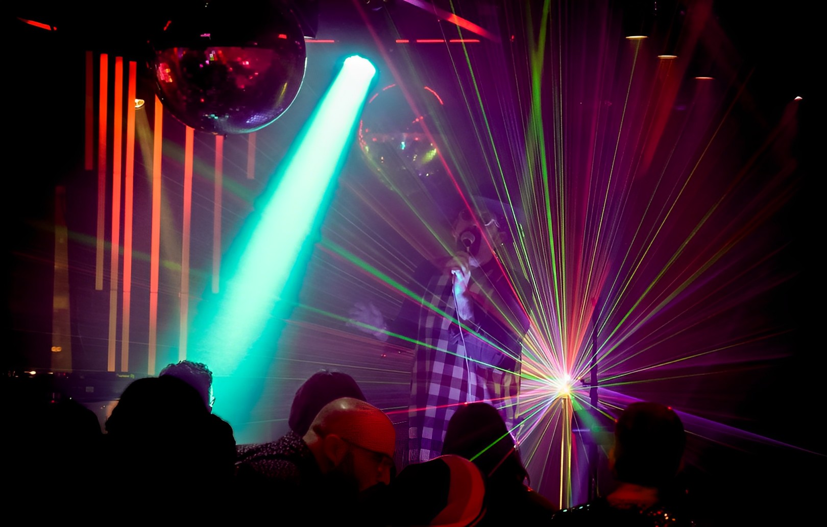 A singer on stage with lasers behind him