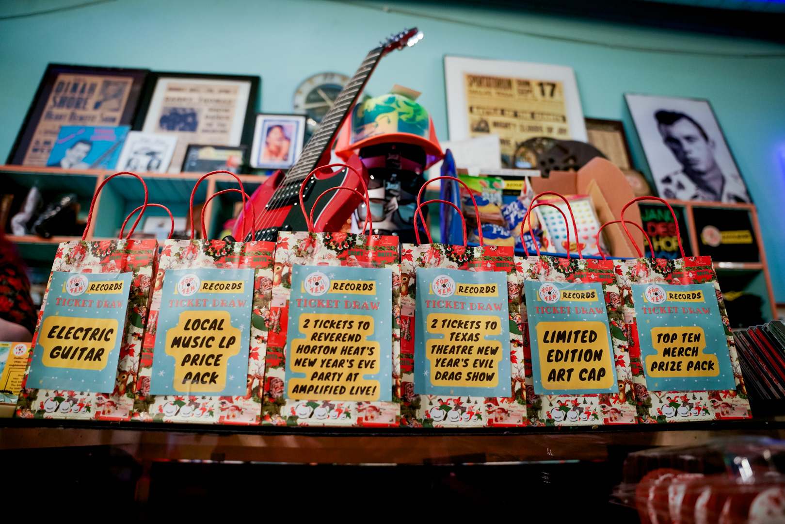 A red guitar and gift bags across a counter