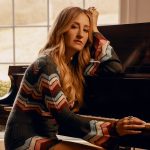 Seated at a piano, Margo Price looks toward the camera