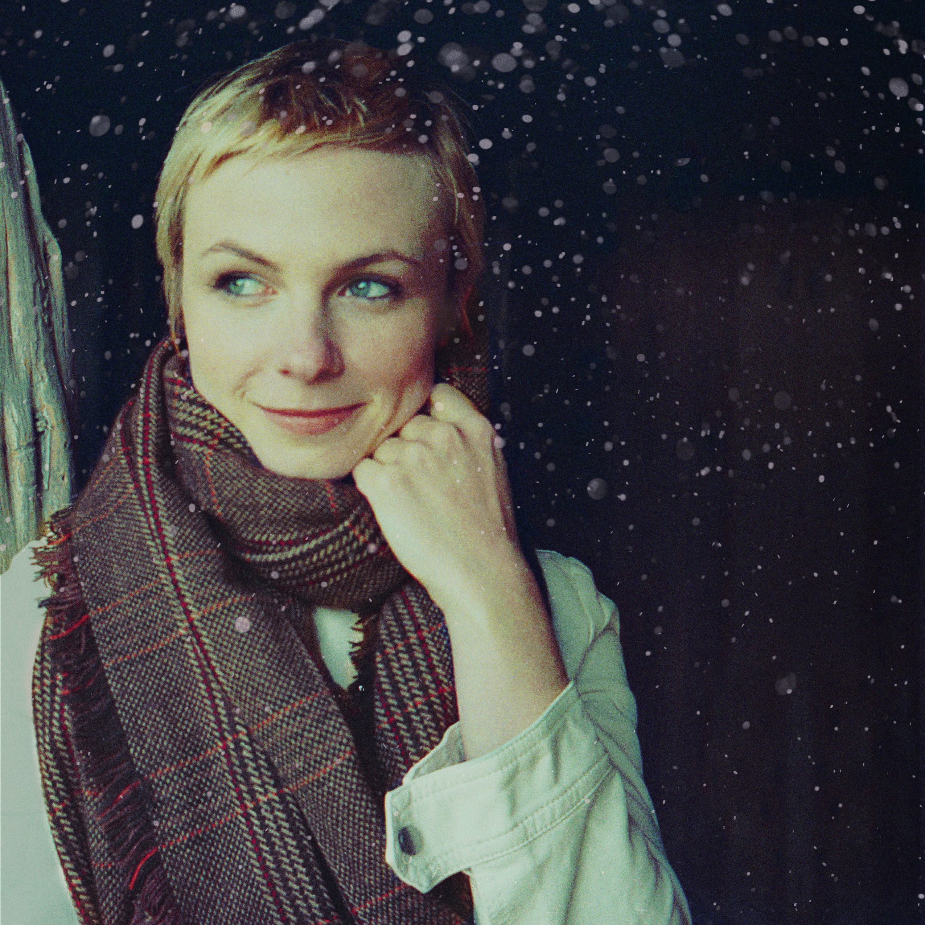 Wearing a scarf, Kat Edmonson looks off to the left