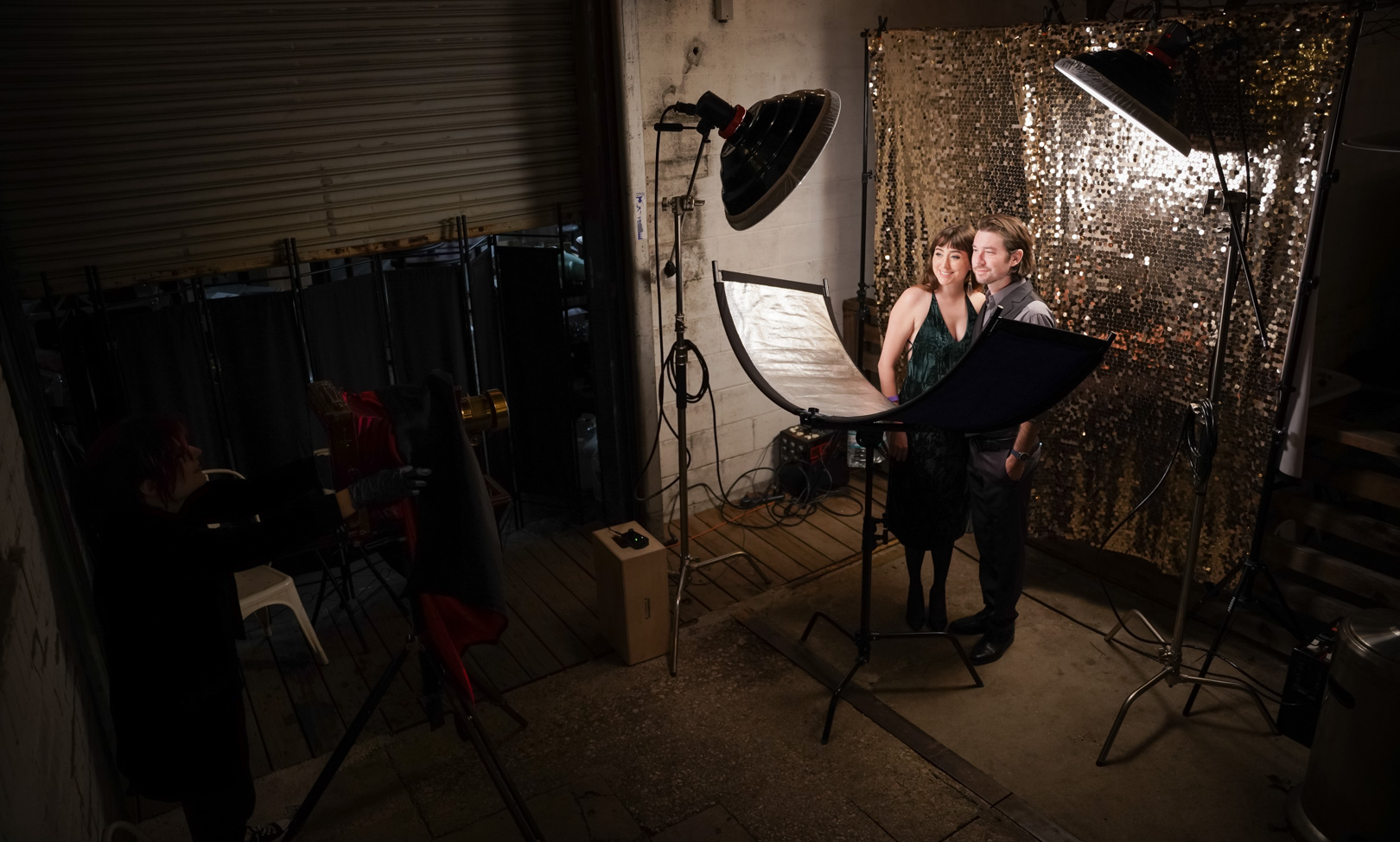 A photo booth with a a backdrop, lighting and a large vintagecamera