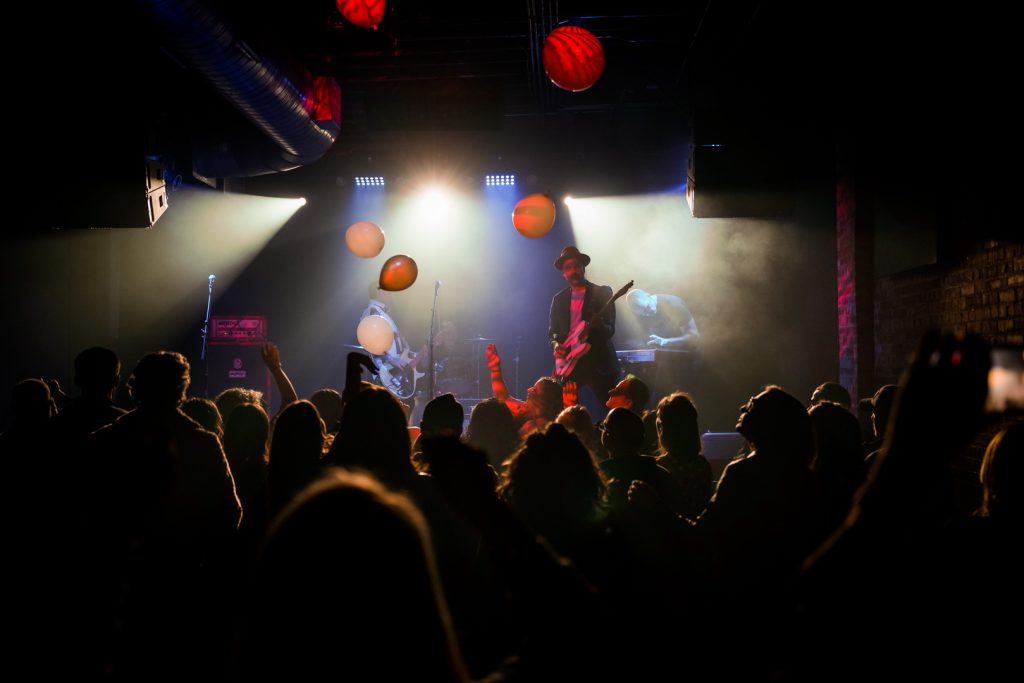 A full band on stage, a full crowd, and balloons in the air