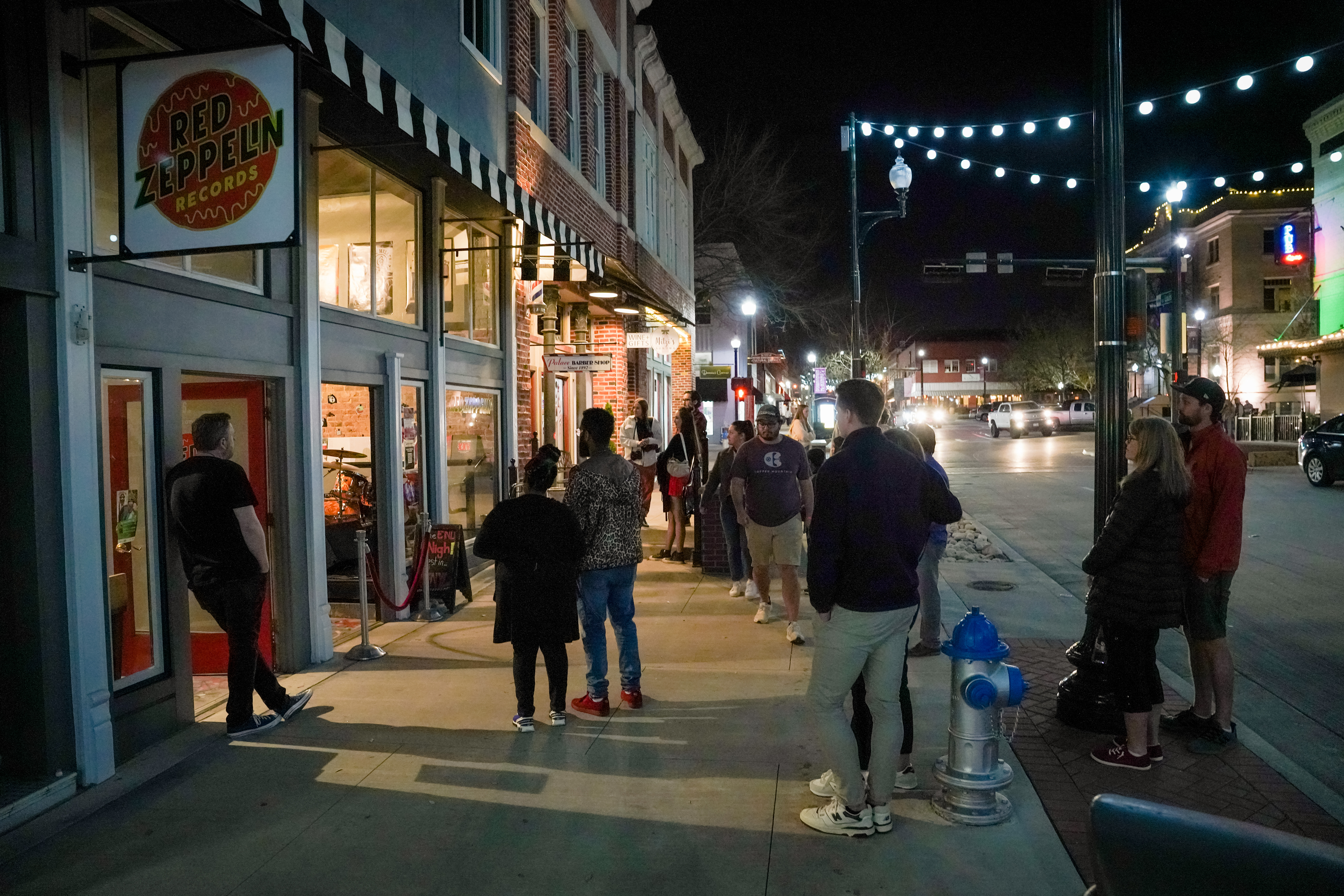 People gathered on the sidewalk outside a record store