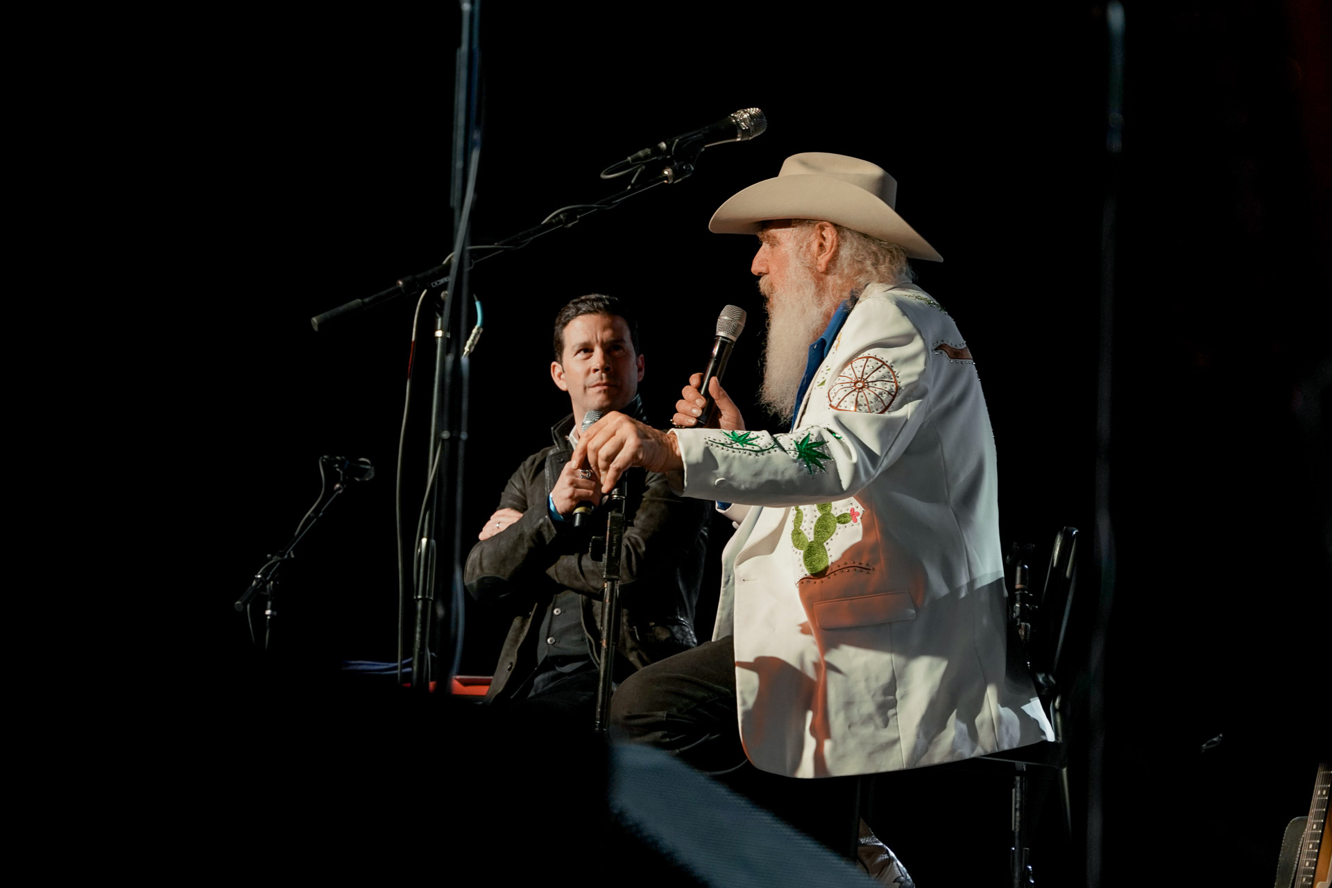 Two men sitting an talking on stage