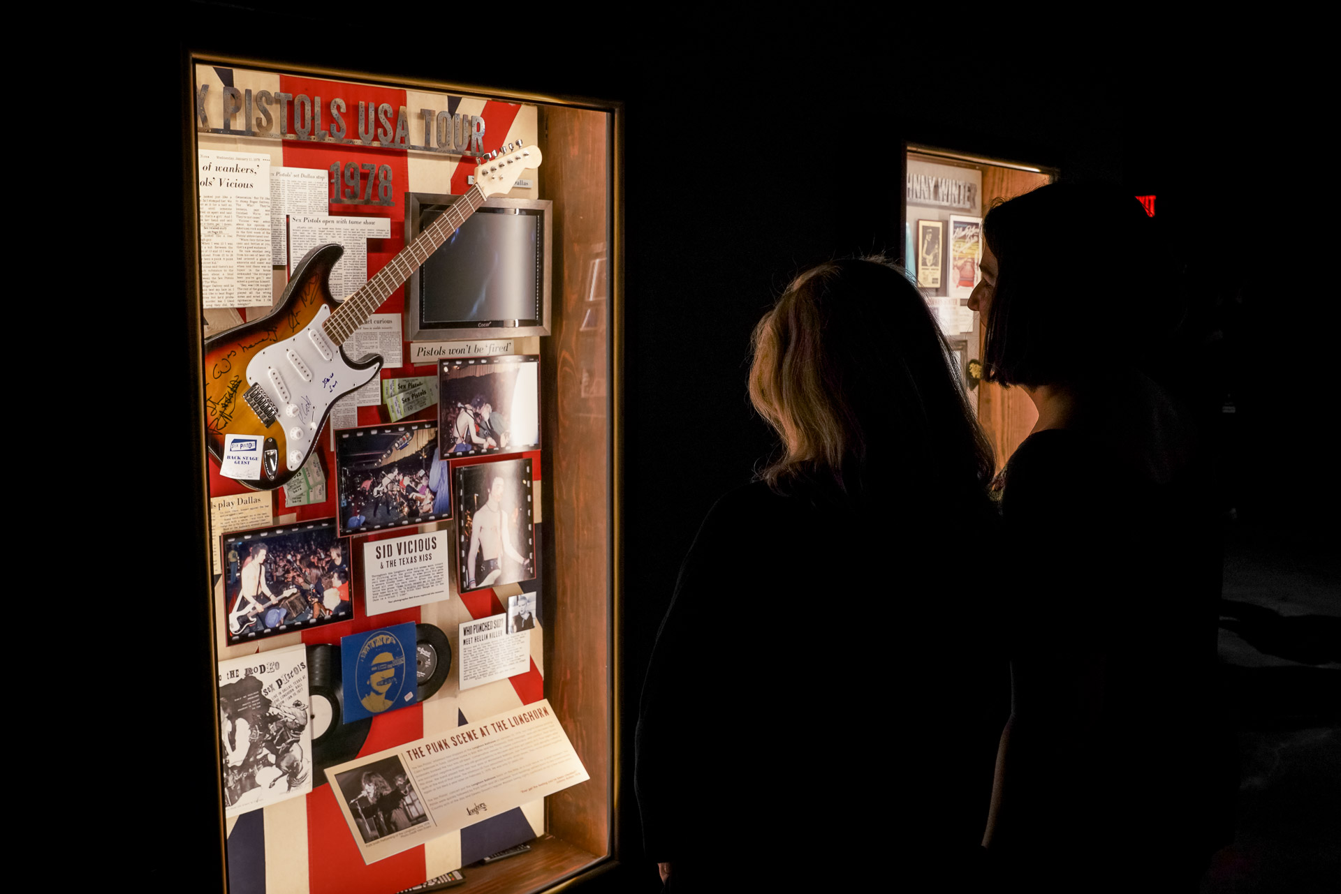 Two people looking at a shadow box with music history artifacts