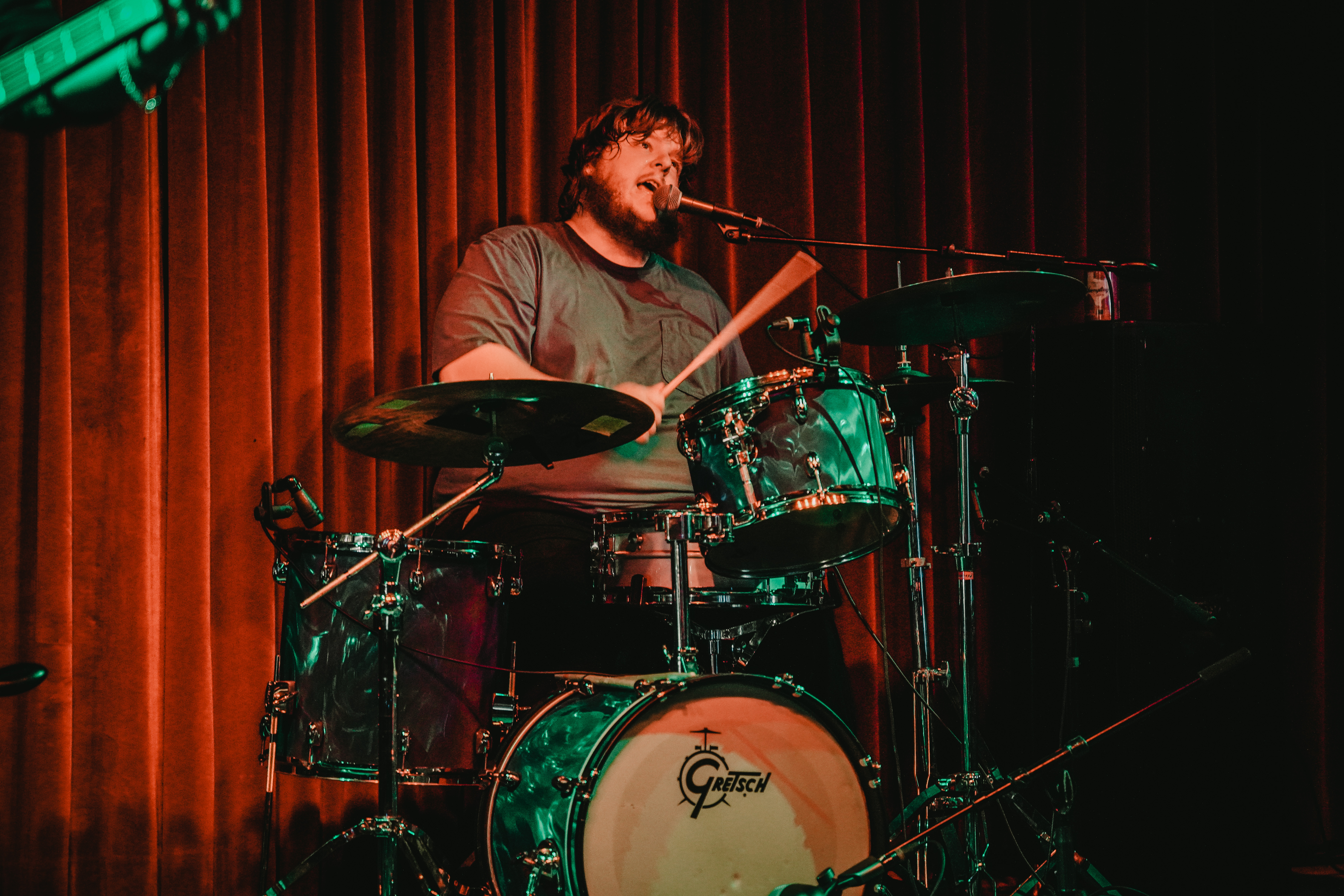 A drummer singing on stage