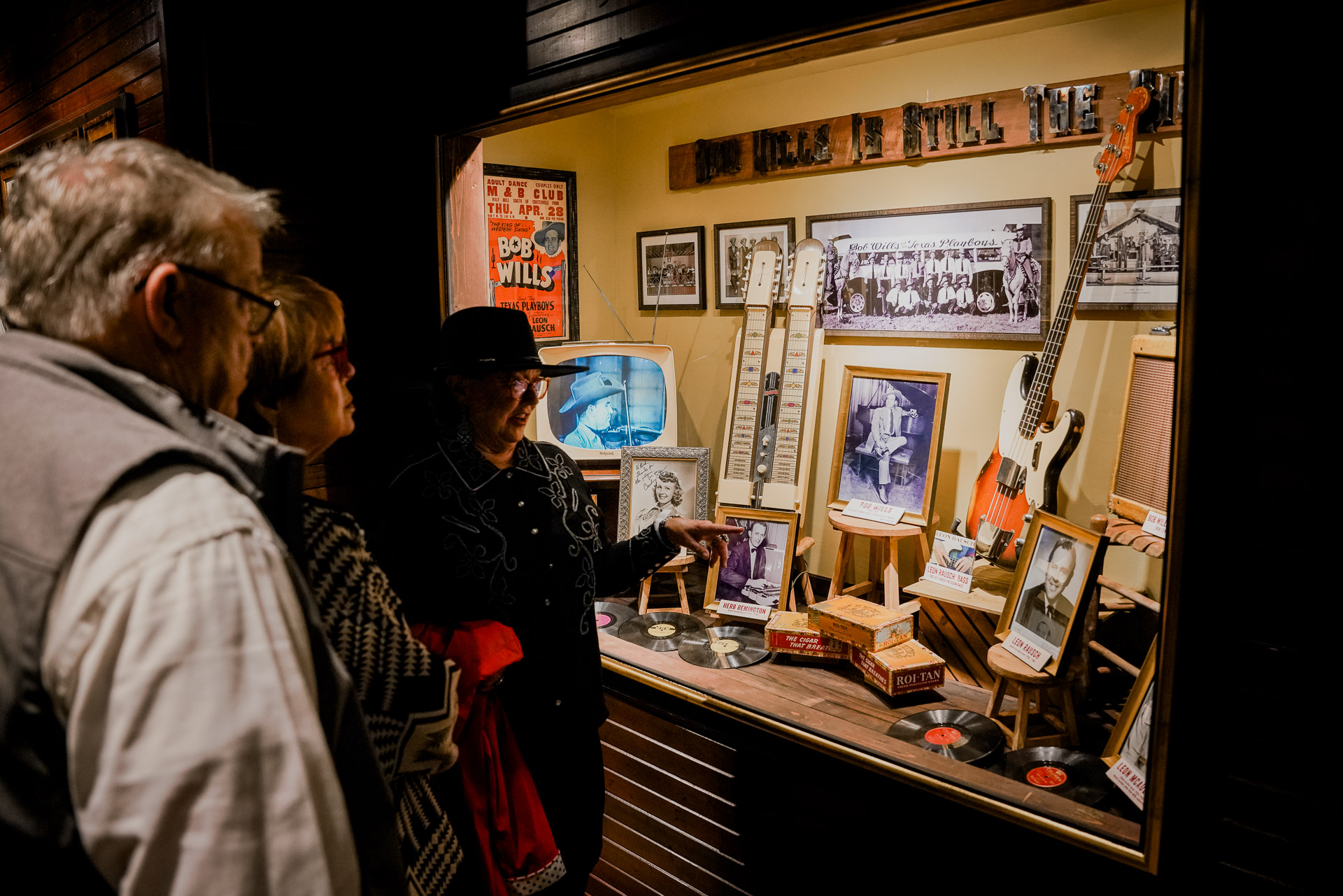 People looking at a case full of music history artifacts