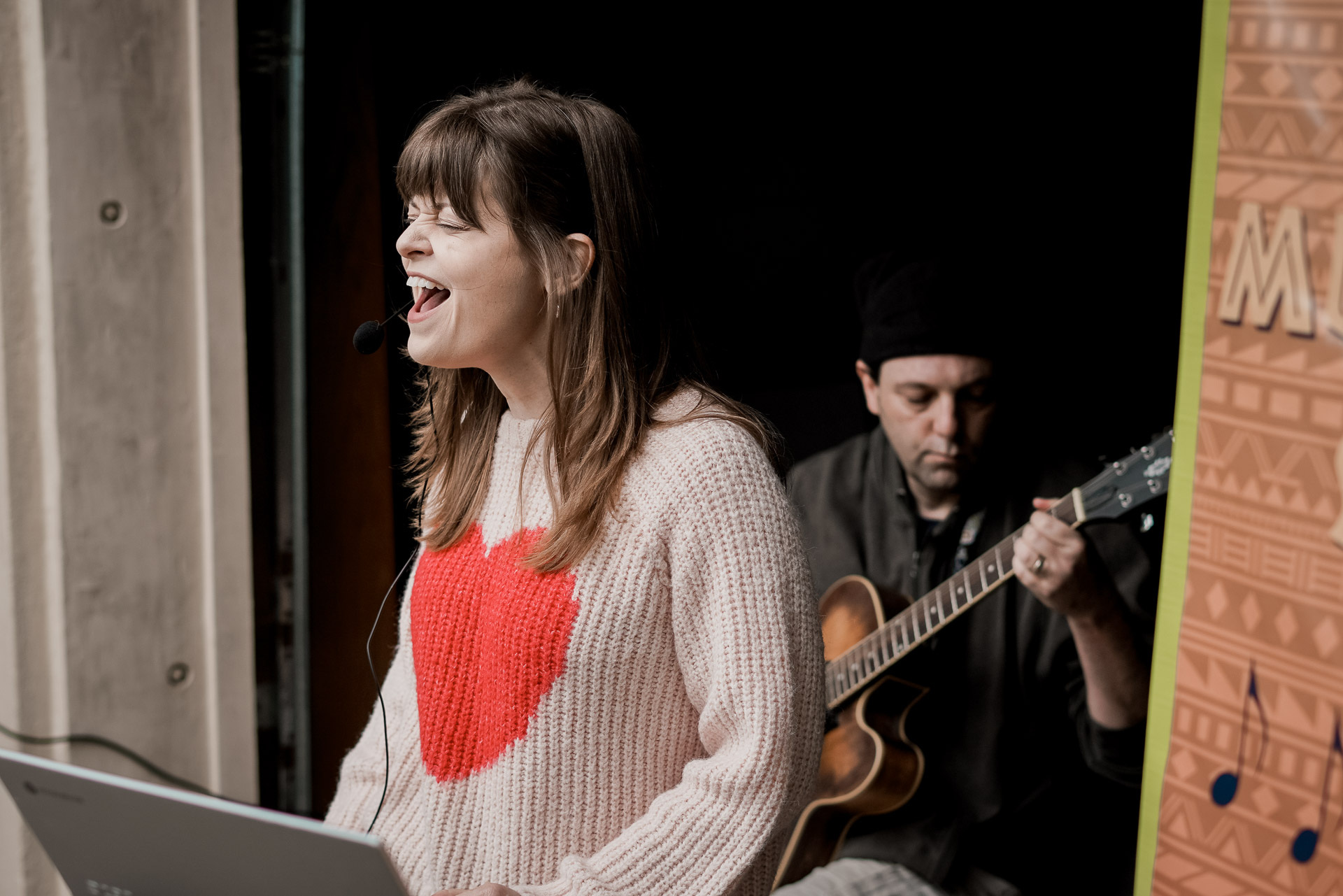 A woman singing and a man playing guitar