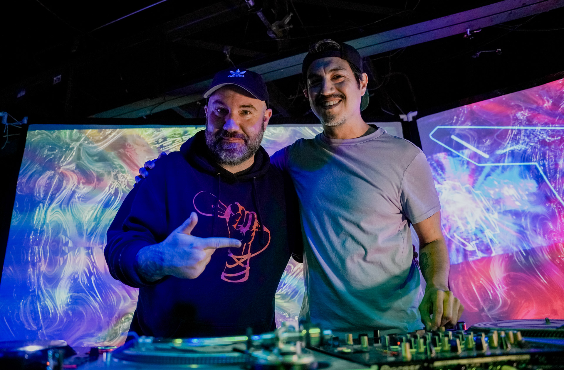 Two djs smiling onstage