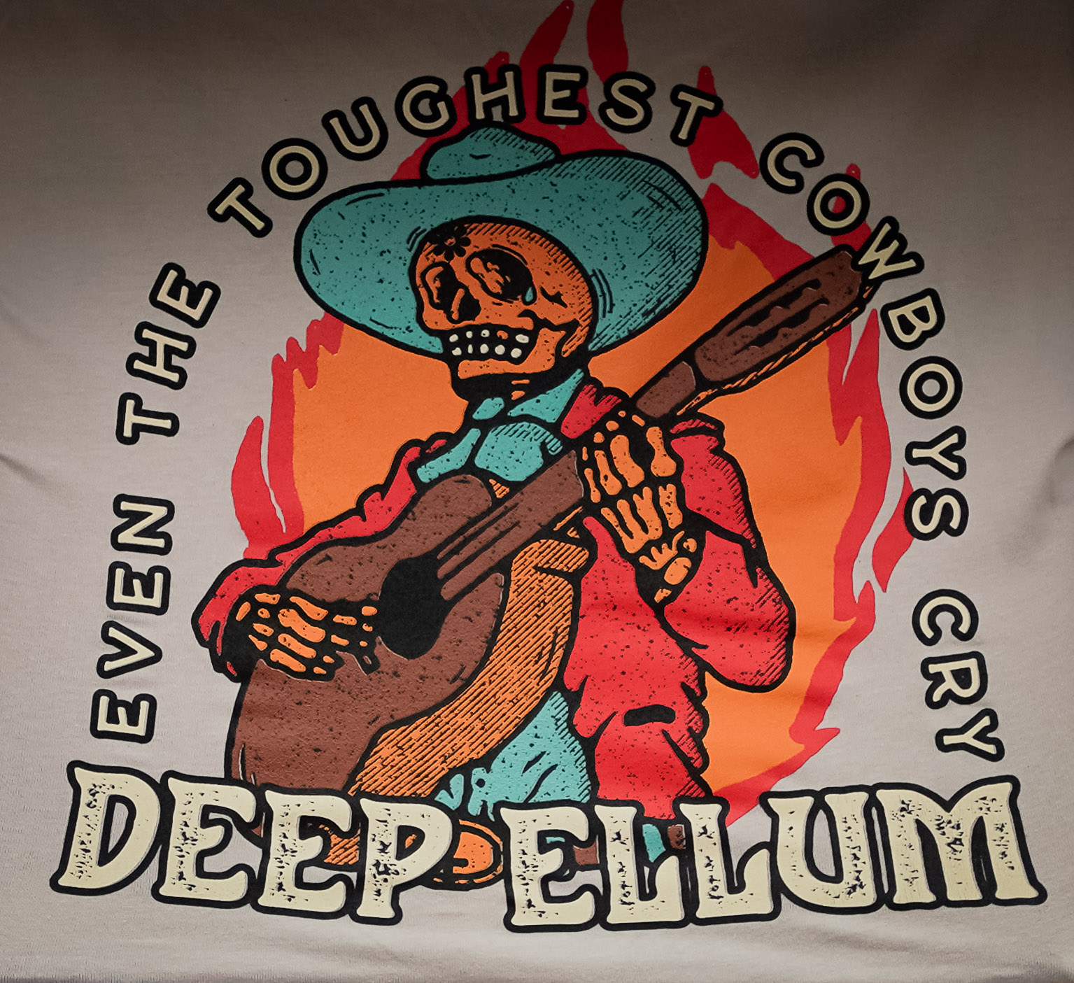 A t-shirt design with a skeleton cowboy playing guitar