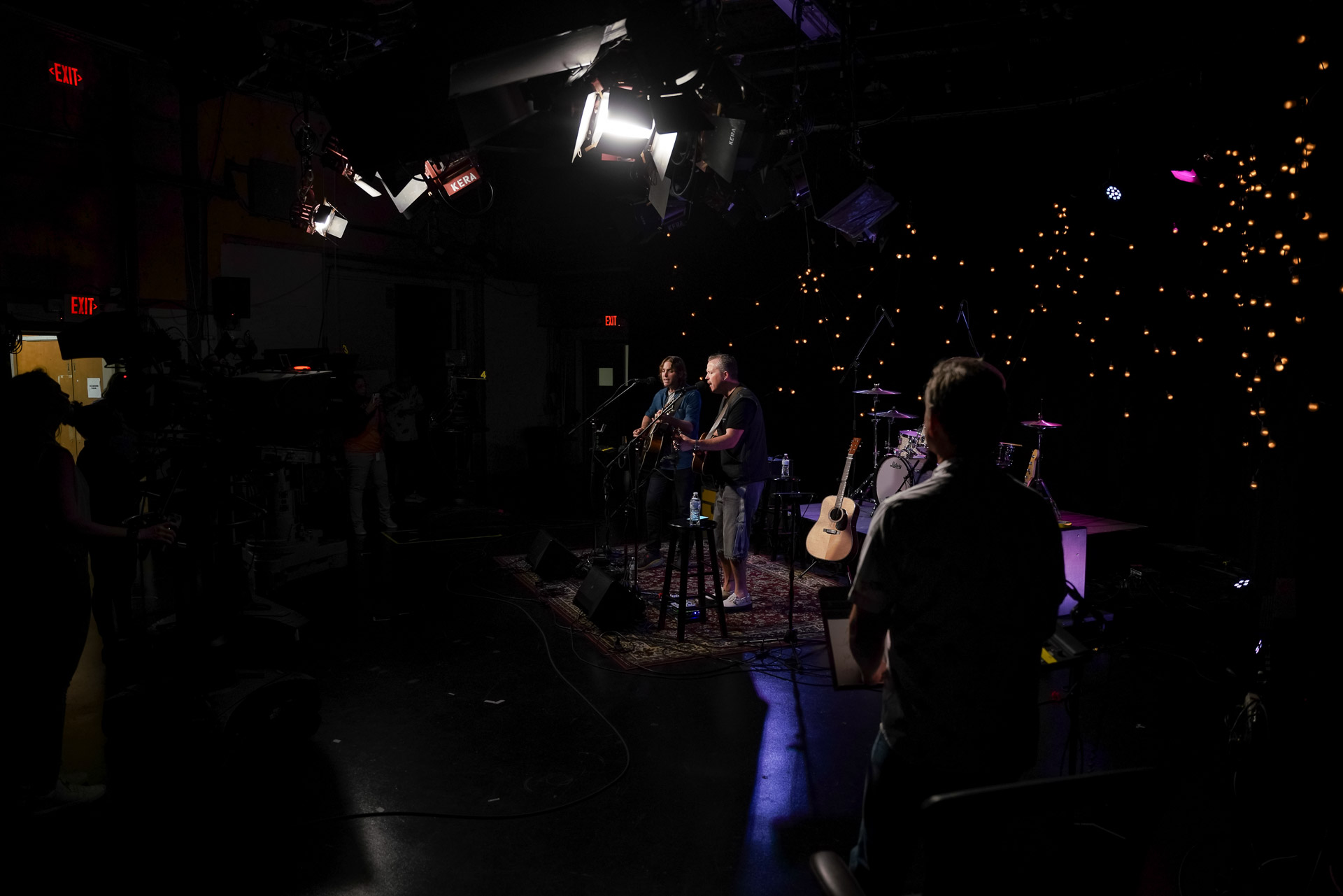 A large studio with cameras pointed at two men performing music