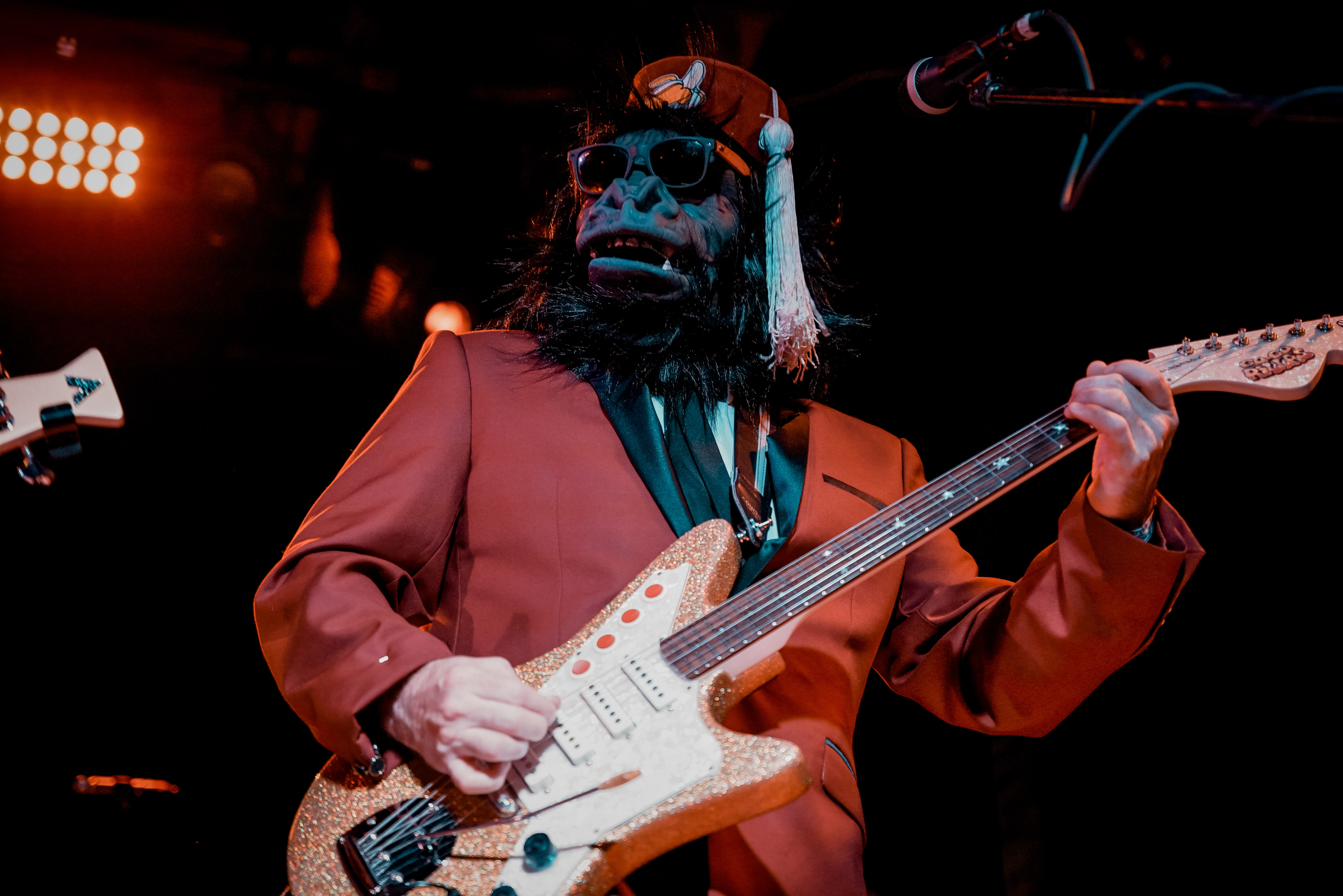 A musician in a gorillas costume playing guitar