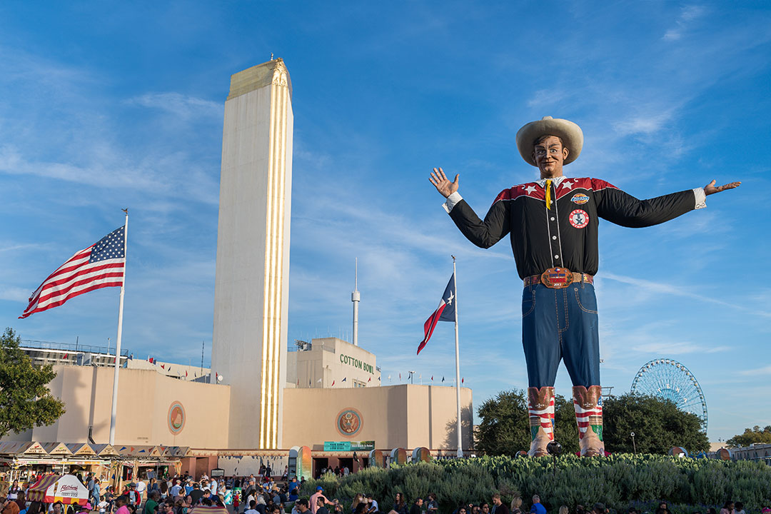 Big Tex and the American flag are shown in front of the Cotton Bowl in Fair Park.