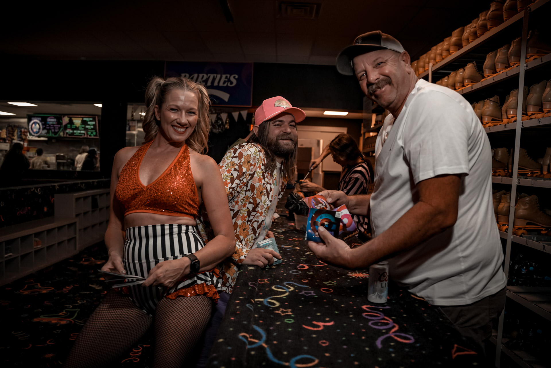 Three people smiling at a roller skate rental booth