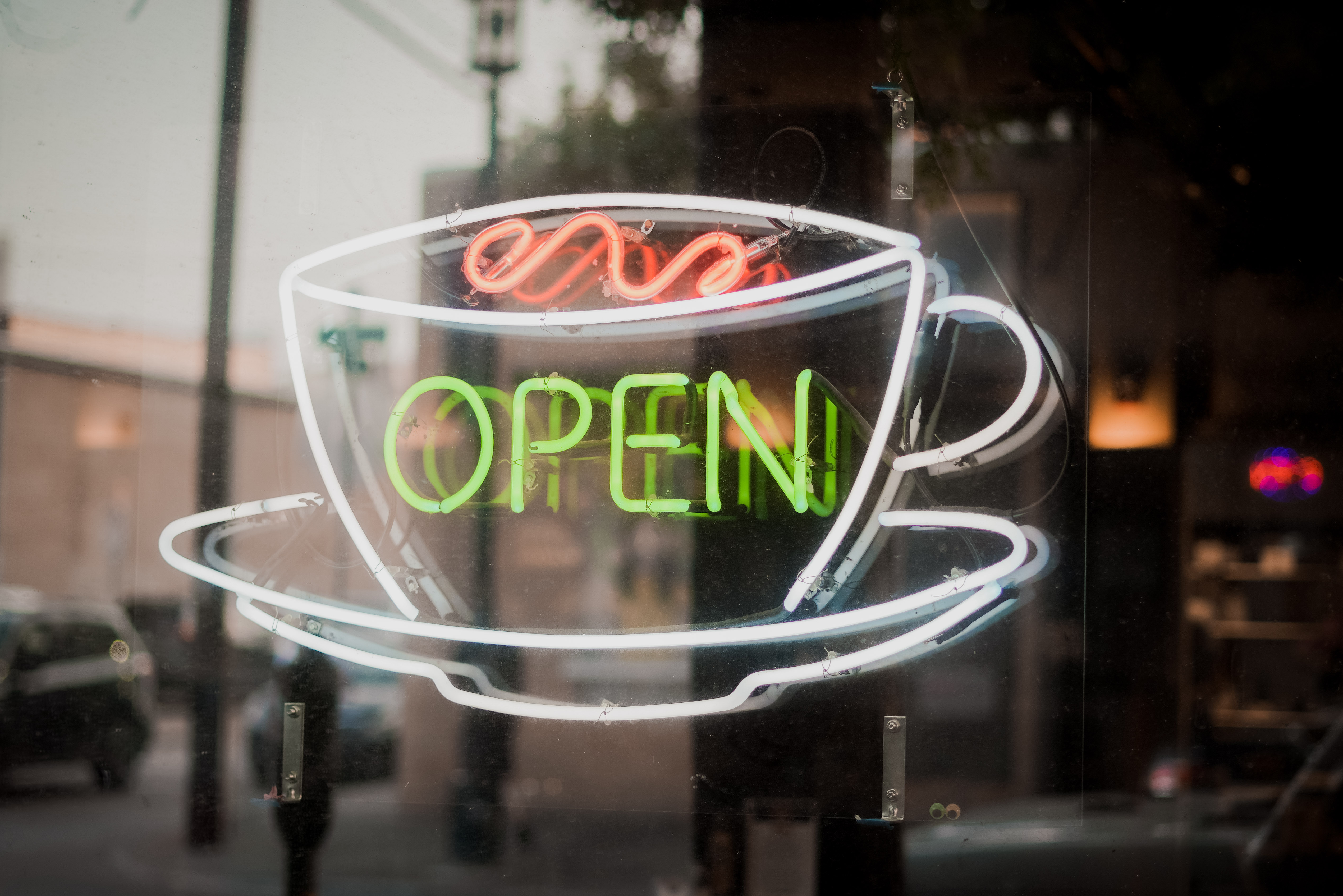 A neon sign with coffee that says "open"